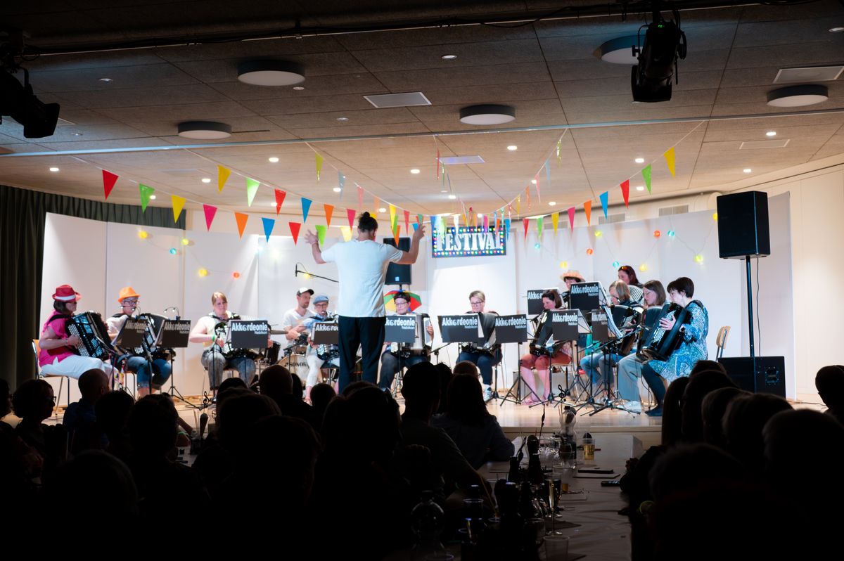 Die Akkordeonie auf der Bühne am Festival-Konzert, der Dirigent mitten im Stück vor dem Publikum.